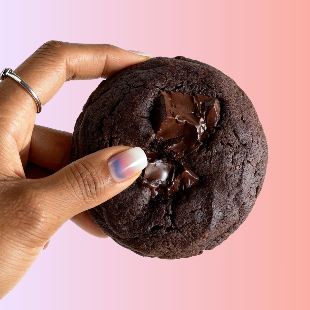 Hand holding a Choco Brownie Cookie from Queen Cookies – rich, dark, and loaded with chunks of melted chocolate
