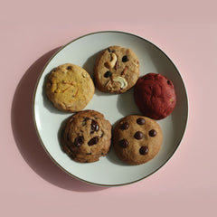 Assorted handcrafted eggless cookies by Queen Cookies India, featuring red velvet, chocolate chunk, dry fruit, saffron pistachio, and choco chip varieties — perfect for premium gifting and nationwide delivery from queencookies.in