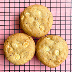 Three Biscoff White Choco Chip Cookies on a cooling rack, showing their golden-brown texture and melted white chocolate chips