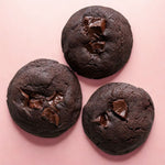 Three Choco Brownie Cookies arranged on a pink background, showing their fudgy and soft-baked centers.