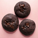 Three Choco Brownie Cookies arranged on a pink background, showing their fudgy and soft-baked centers.